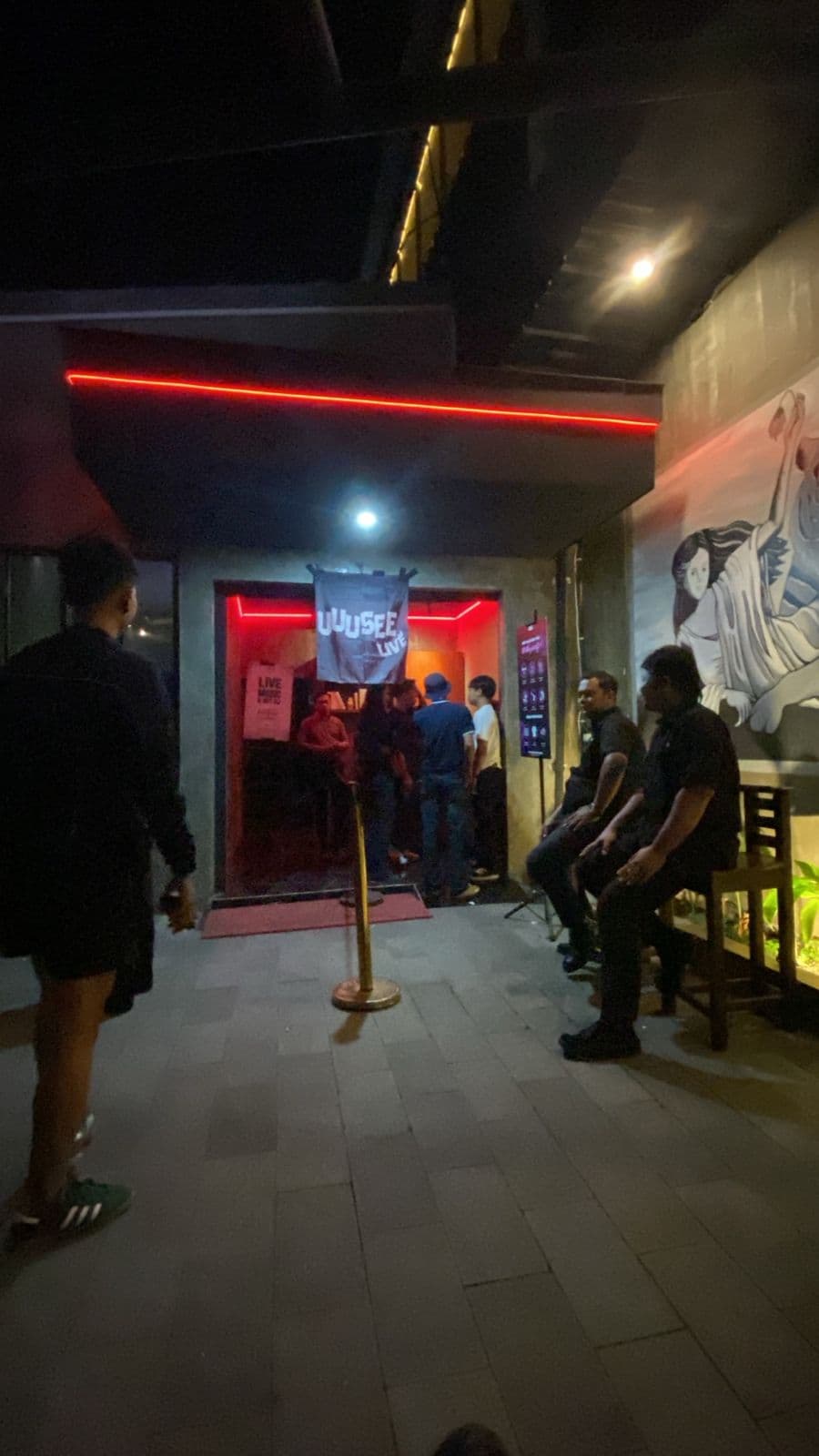 Venue entrance with red lighting as guests arrive