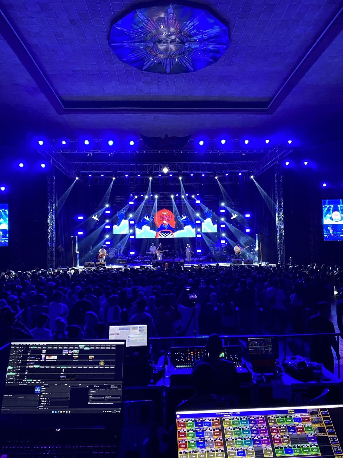 Concert stage lit in blue, seen from the production booth